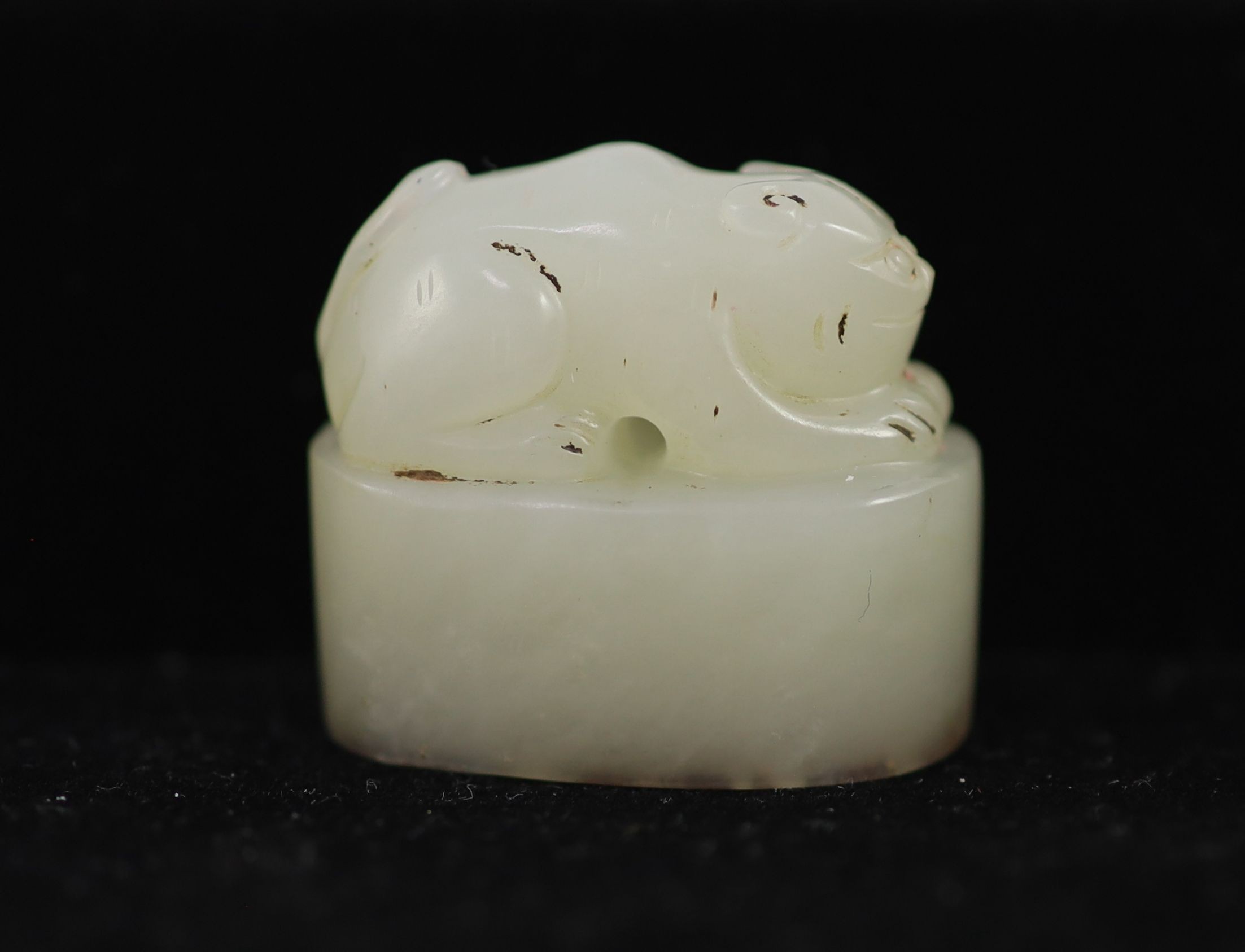 A Chinese white jade and oval 'crouching cat' seal, 2.9 cm